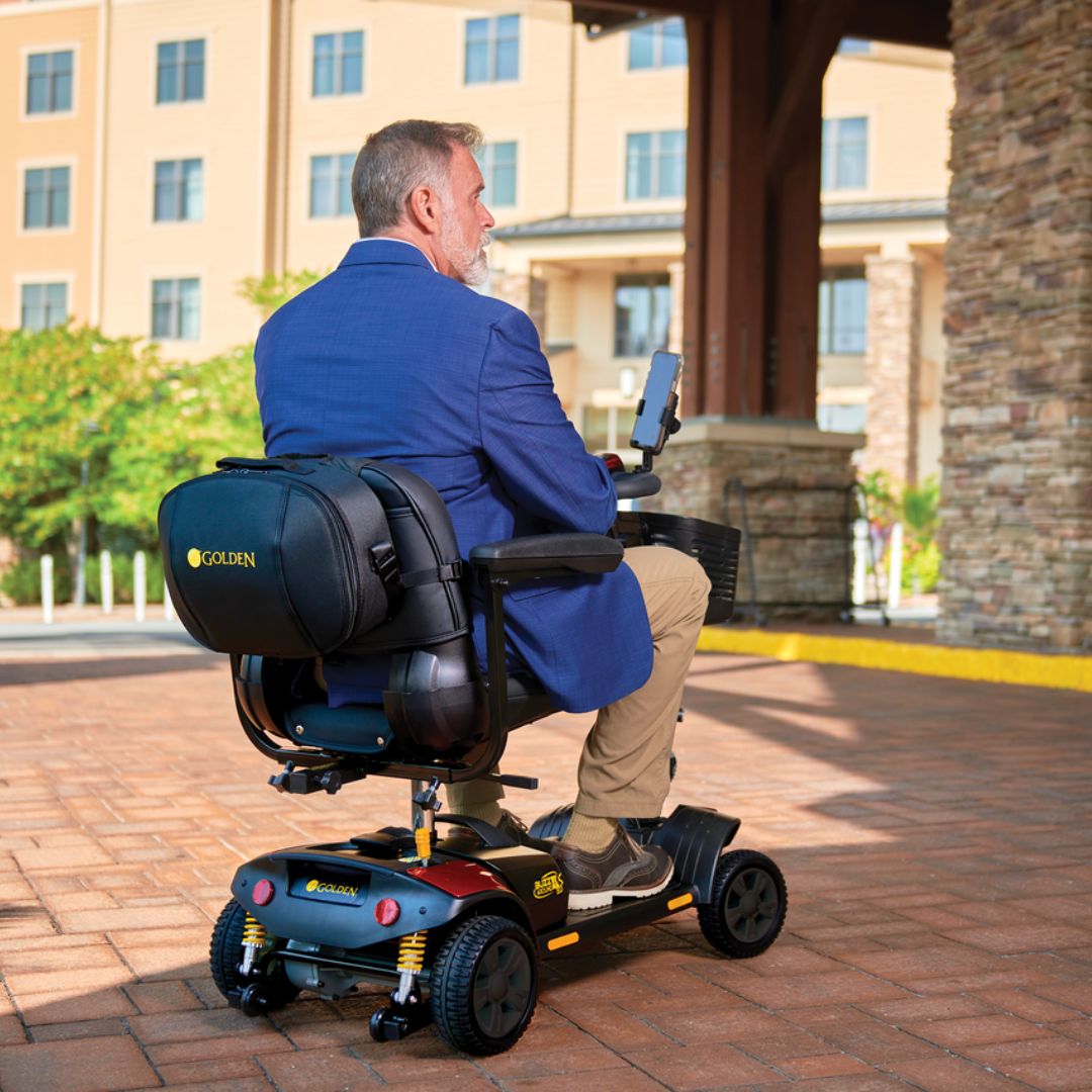 Buzzaround XLS-HD 3-Wheel by Golden Technologies Outside with Man Riding It