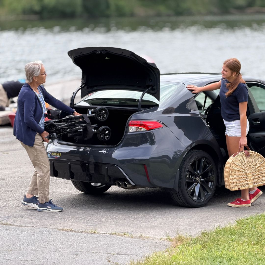 Senior putting the Golden Technologies Cricket LT Carbon Folding Power Wheelchair into Trunk