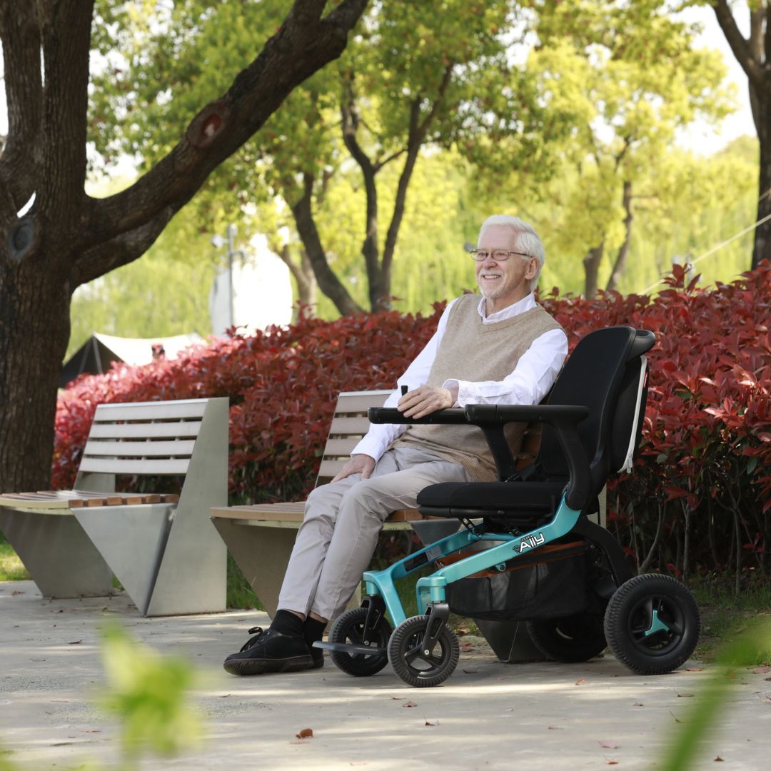 Man using a Ally power wheelchair in a park setting