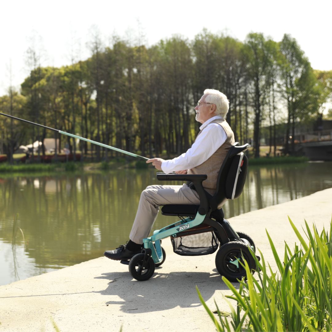 Man using a Golden Ally Power Wheelchair fishing by a lake