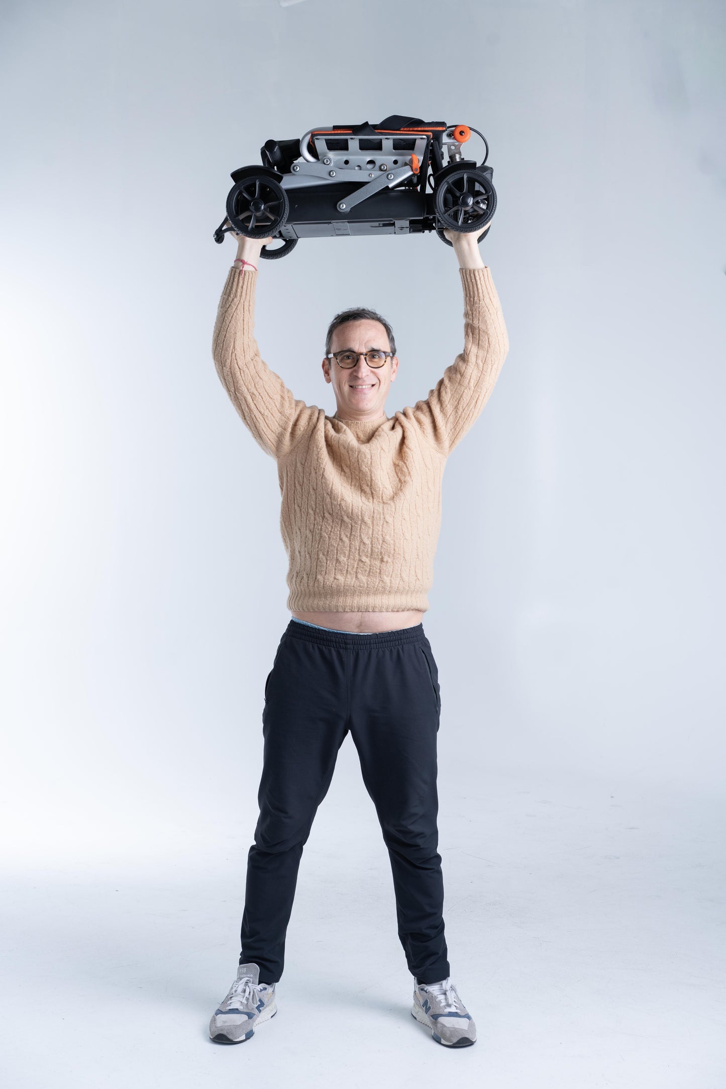 Man Holding Feather 27X Folding Mobility Scooter Above His Head