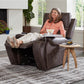 Woman relaxing in a Golden Technologies Cloud PR448 Titan Maxicomfortwith a side table in a living room setting.
