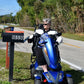 Person on a EV Rider Vita Monster Heavy-Duty Mobility Scooter in Blue by a mailbox with trees in the background