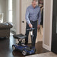 Man using EV Rider Transport 4AF Automatic Folding Travel Mobility Scooter in blue inside home