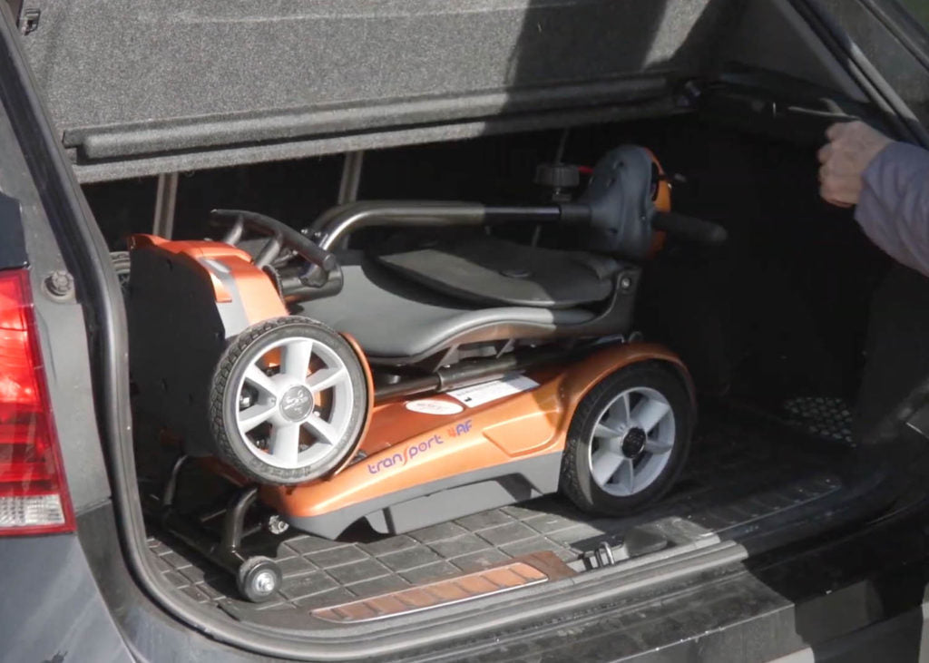 EV Rider Transport 4AF Automatic Folding Travel Mobility Scooter in Gold in trunk of a car.
