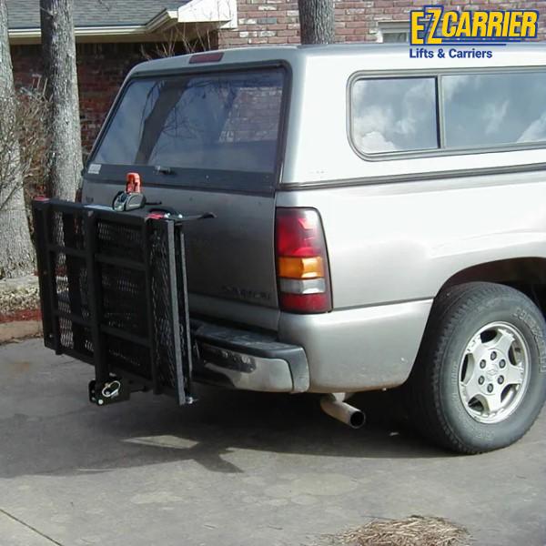Van with a black EZ Carrier lift and carrier system attached to the back, parked on a driveway.