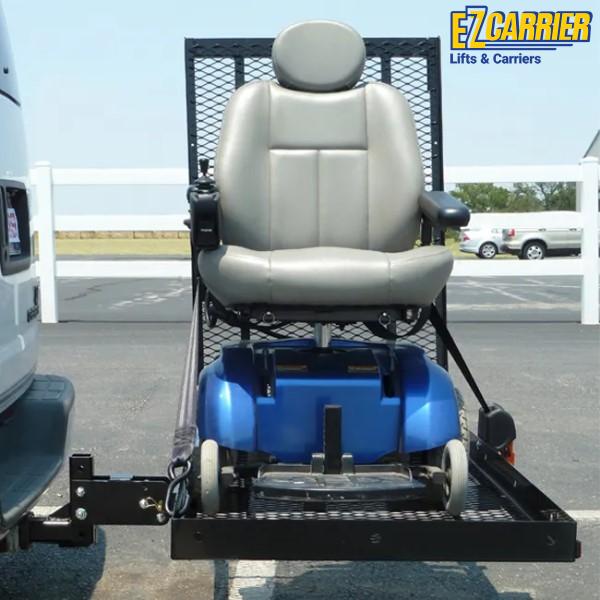 Elevated wheelchair on a lift carrier with 'EZ Carrier' branding in an outdoor setting.